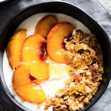 زبادي بالخوخ والجرانولا والعسل في طبق أسود