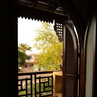 إطلالة من شيش خشبي على نخيل دهب وجبالها